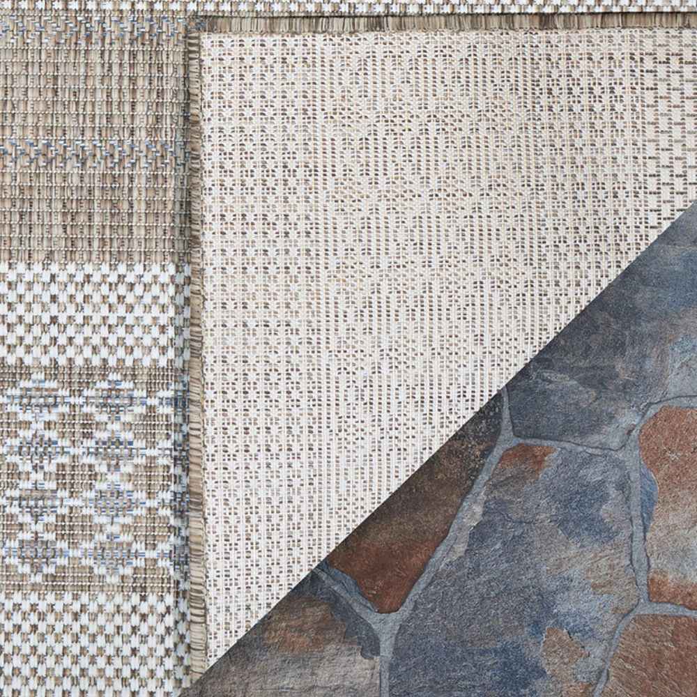The underside of the Couristan Charm Indoor/Outdoor Rug - Yukon/Twig is visible in one corner
