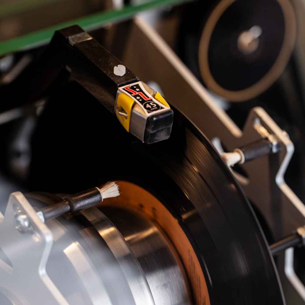 The vinyl arm of the Marshall Rocket Vinyl Jukebox - Black is shown engaging a record