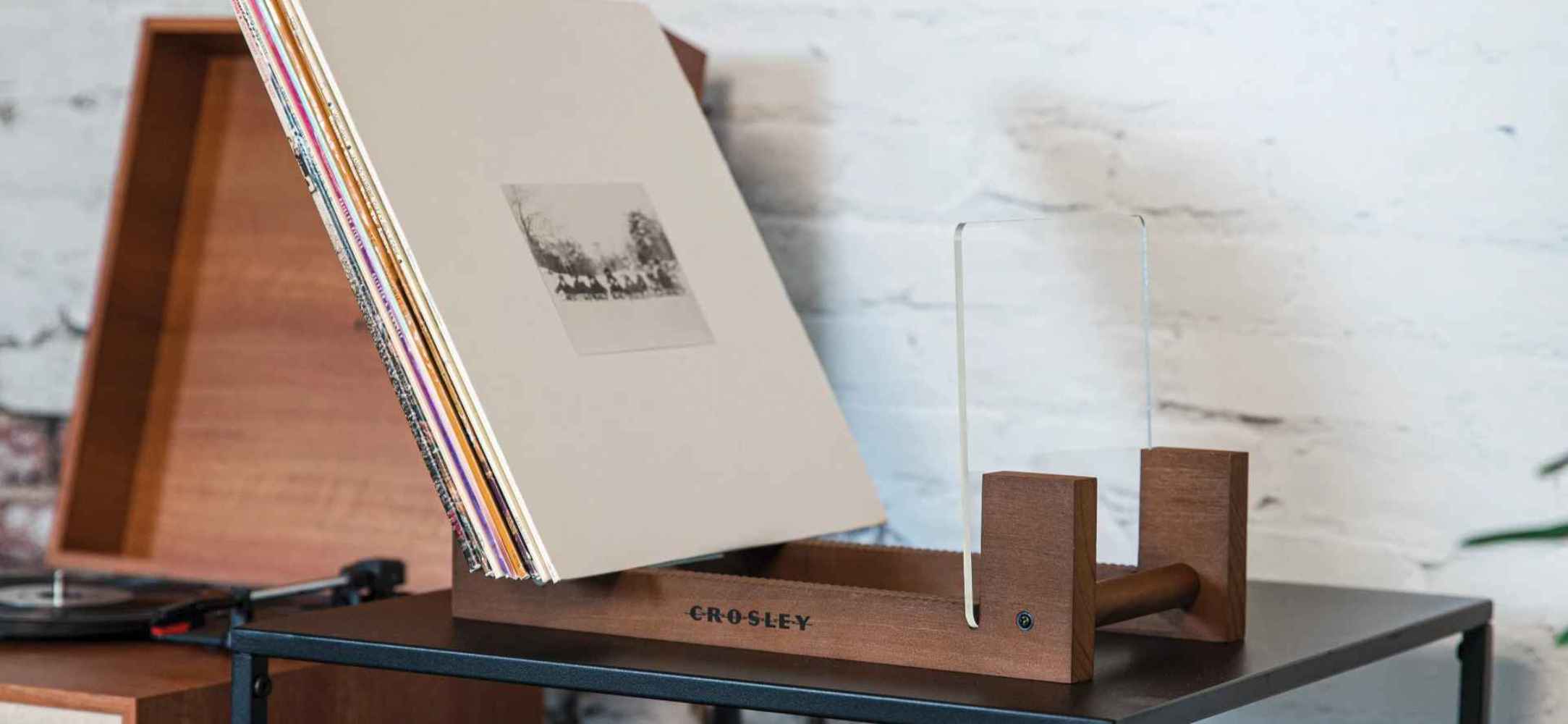 This Crosley Record Storage Display Stand - Natural keeps records upright with a wooden base and clear acrylic panels