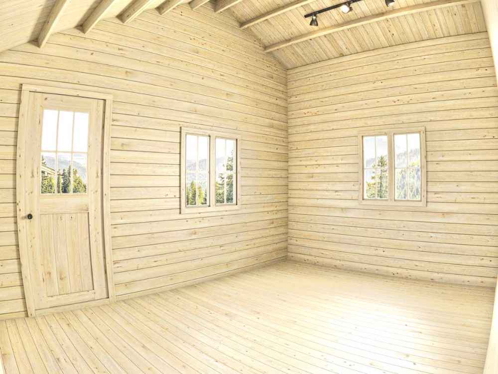 This empty wooden interior with pale planks and high ceilings highlights the raw space of a Sawmill Structures BlueWater Bungalow 160 Garden Room