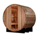 Three-quarter view of Golden Designs St. Moritz 2 Person Barrel Traditional Sauna showing its round cedar front, a glass door with a long handle and a bench inside on black cradles