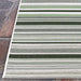 Top corner of Couristan Dolce Indoor/Outdoor Rug - Striped/Grass is displayed neatly against a stone surface