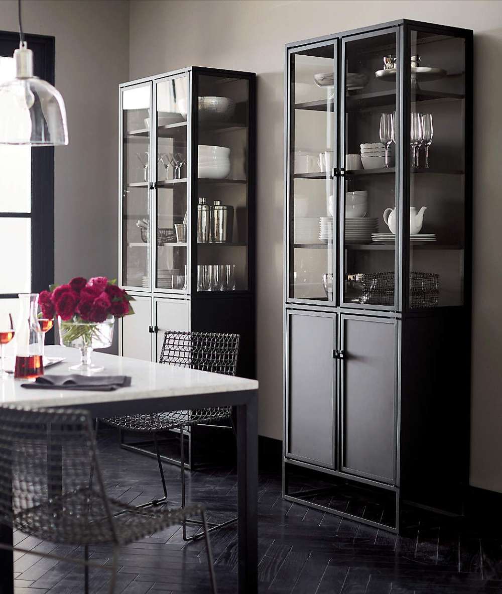 Two Crate & Barrel Casement 32" Black Storage Cabinet units display dishes, glassware, and serving pieces in a modern dining room