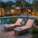 Two poolside loungers sit beside the glowing Outdoor Order Curve Infrared Heater in a landscaped backyard at dusk