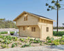 Two-story wooden cabin surrounded by lush greenery and outdoor seating showcases the exterior of Sawmill Structures The Northwood Grand SD 70mm Garden Room