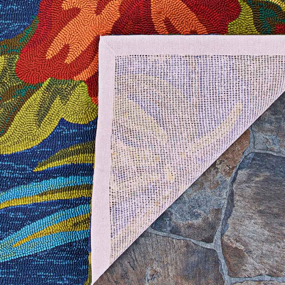 Underside of the Couristan Covington Indoor/Outdoor Rug - Tropical Orchid/Azure-Forest Green-Red reveals a durable mesh backing for outdoor stability