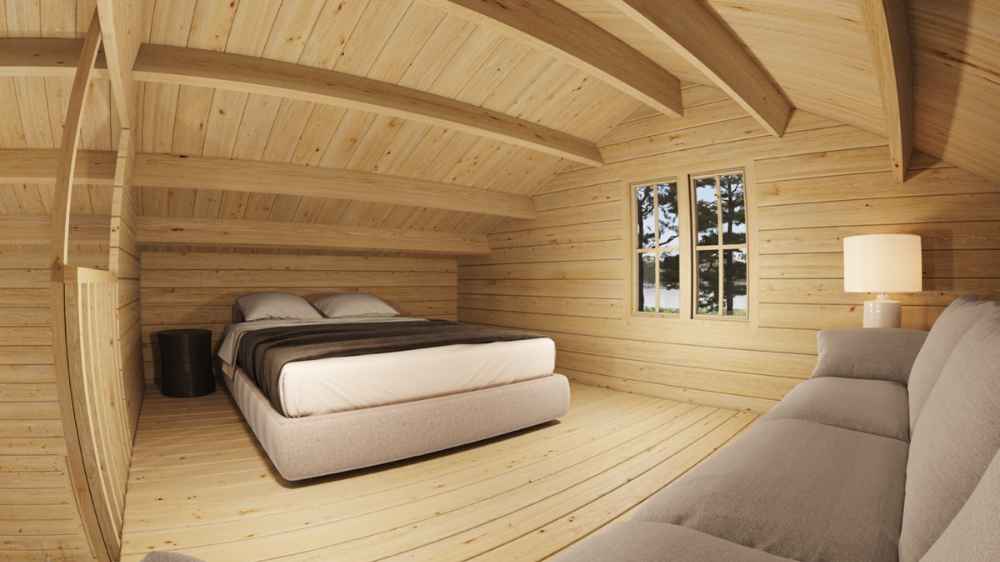 Upper loft of Sawmill Structures The Northwood Grand DD 70mm Garden Room includes a bed, a side table, and a couch beneath the wood-beamed ceiling