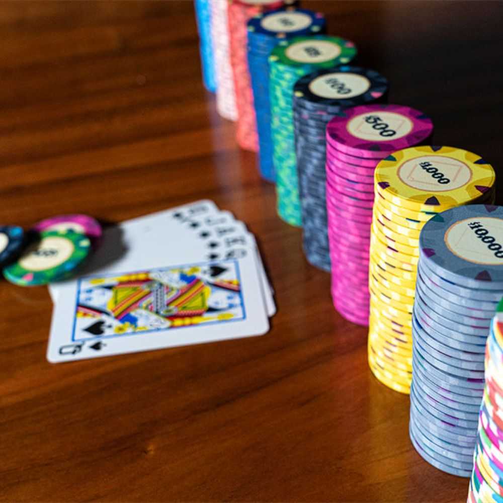 Various BBO Poker Tables 500-Piece Classic Casino Poker Chips are neatly arranged in rows, showing denominations from $5 to $100,000