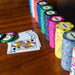 Various BBO Poker Tables 500-Piece Classic Casino Poker Chips are neatly arranged in rows, showing denominations from $5 to $100,000