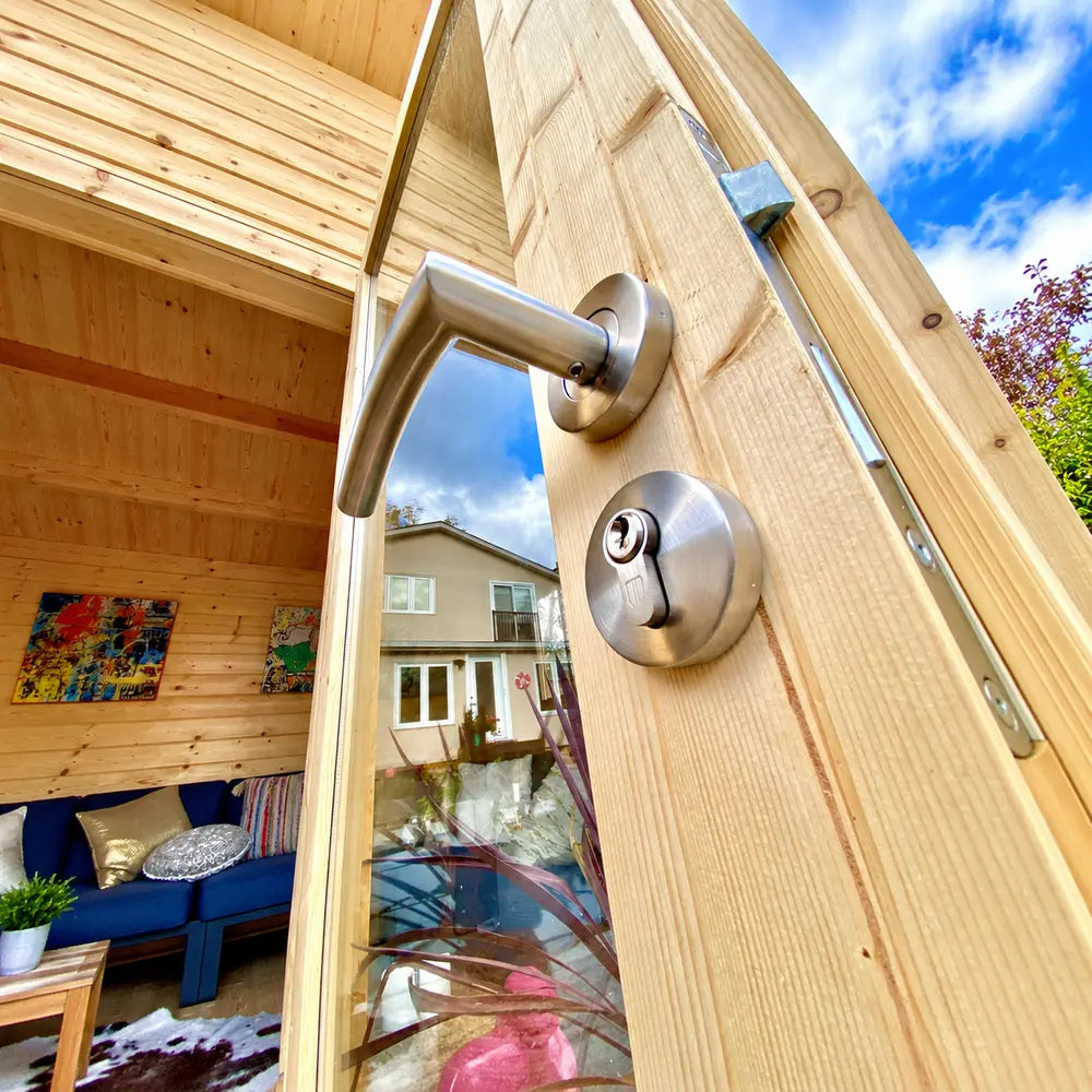 Close-up of the Versa 107 70MM wooden door with a brushed-metal lever handle, round cylinder lock, hinge hardware, and reflective glass panel.