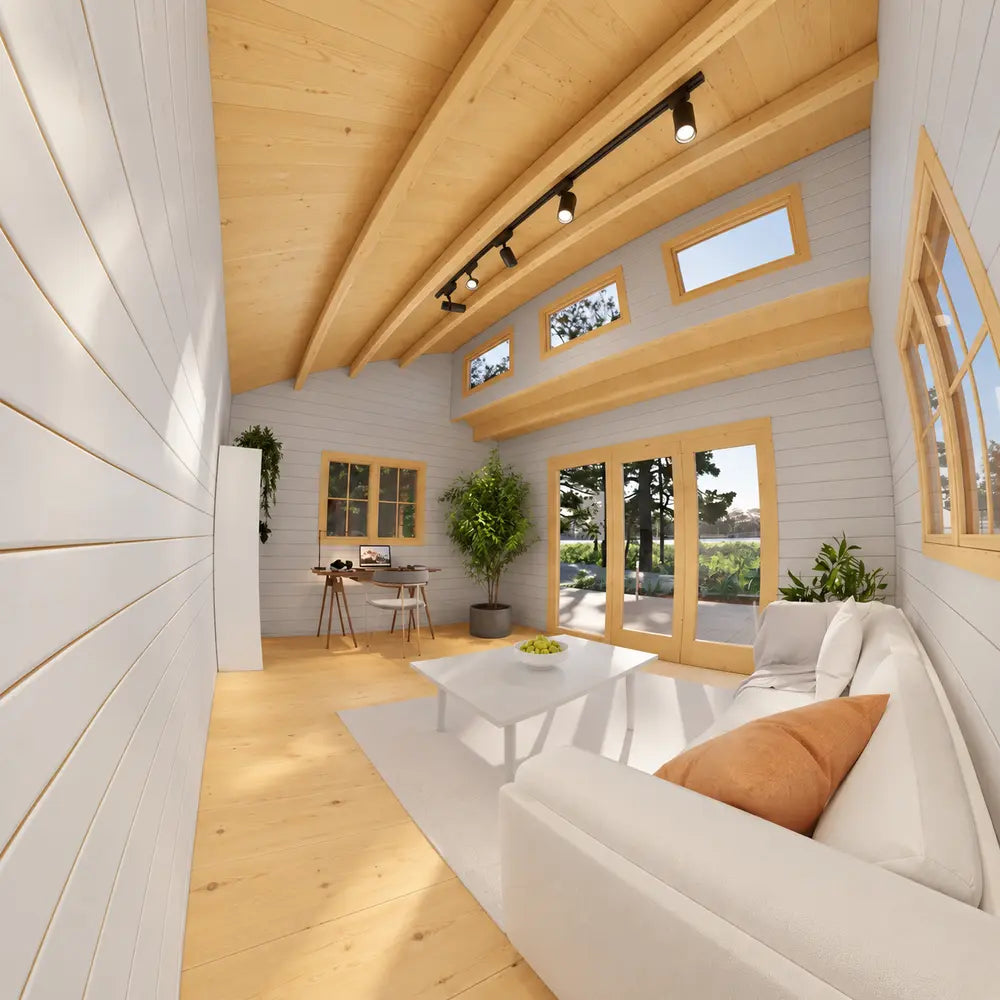 Sunlit Versa 160 Atrium 70MM interior with a white sofa, desk, potted tree, tall glass doors, clerestory windows, and exposed curved beams.
