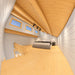 Versa 160 Atrium Loft 70MM bedroom with a low sloped wooden ceiling, exposed beams, three horizontal windows, a central bed, bedside lamps, and loft railing.