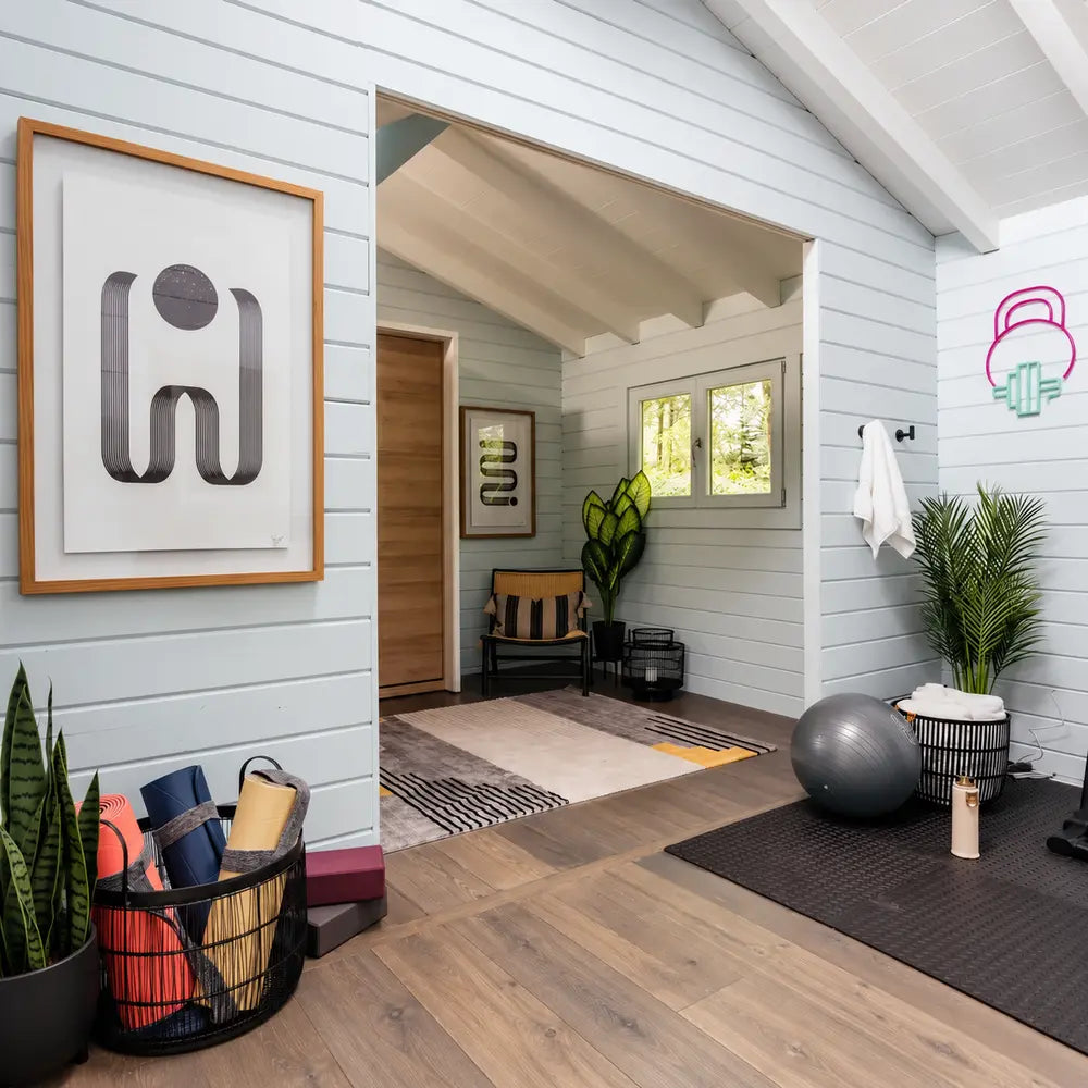 Serene Versa 240 70MM wellness interior with yoga mats and blocks, an exercise ball, plants, abstract wall art, a patterned rug, and a woven chair.