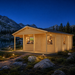 Vienna 70 glowing beside a Wyoming alpine lake while family and friends watch football inside.
