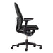 Viewed from the side, Crate & Barrel Haworth Zody Upholstered Charcoal Office Chair showcases its ergonomic profile, padded seat, and adjustable armrests
