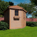 Viewed from the side, the Outdoor Living Today 9×9 Penthouse Garden Shed displays its angular design and classic window box on a lawn