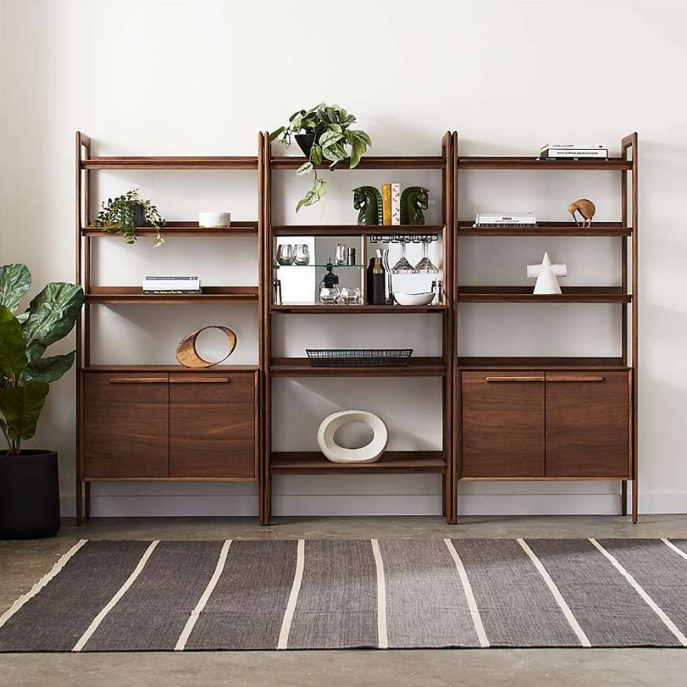 Wall arrangement of modular shelving that includes Crate & Barrel Tate 36" Walnut Wood 3-Shelf Storage Bookcase Cabinet