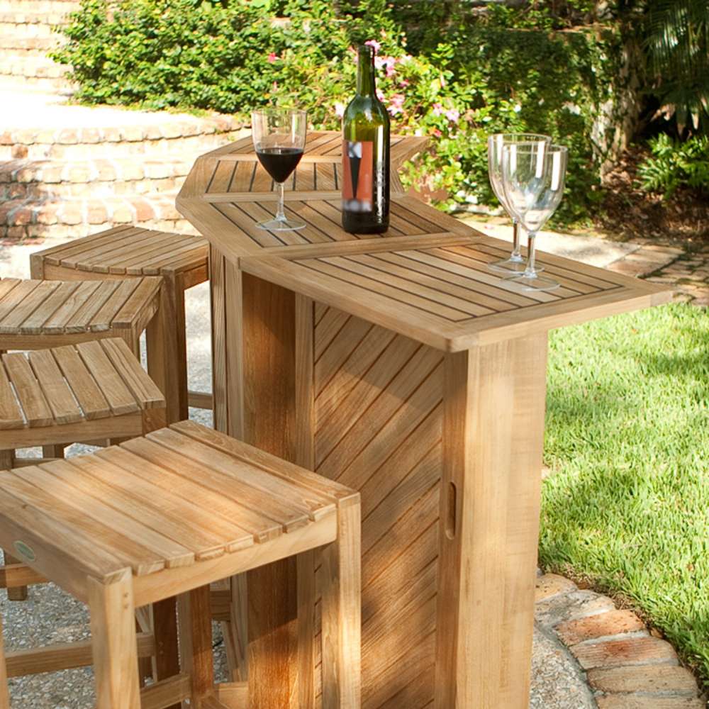 Westminster Teak 5pc Somerset Teak Bar & Stool Set shown on a sunny patio with four stools around the bar, topped with a wine bottle and glasses