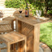 Westminster Teak 5pc Somerset Teak Bar & Stool Set shown on a sunny patio with four stools around the bar, topped with a wine bottle and glasses