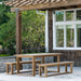 Westminster Teak 6ft Horizon Teak Backless Bench is part of a full outdoor dining set on a patio near a house, with trees and greenery in the background