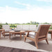 Westminster Teak 6pc Laguna Lounge Seating Set is shown arranged on an outdoor patio rug with cushioned chairs, a sofa, and round teak tables in an open scenic setting