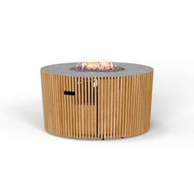 Westminster Teak Agora Fire Table is a round teak slatted fire pit table with a ceramic slate top and a gas flame burning in the center