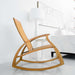 Westminster Teak Aria Rocker appears in a modern room next to a white table and couch, showing how it fits into a home setting