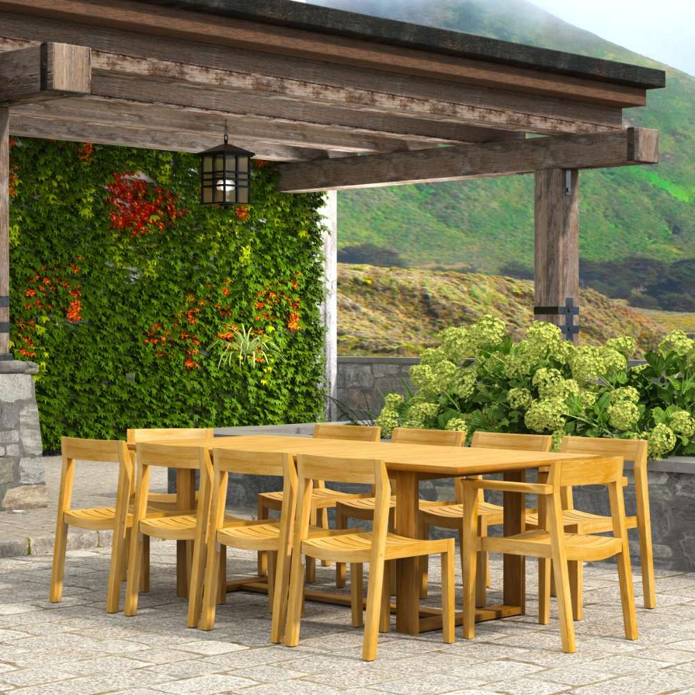 Westminster Teak Horizon 11pc Teak Dining Set is shown from the side under a covered patio, with the long teak table and matching chairs set in an outdoor garden space