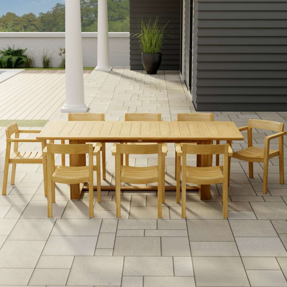 Westminster Teak Horizon 9pcs Teak Dining Set shown on a tiled patio near a house with columns, featuring a large teak table surrounded by eight matching wooden armchairs