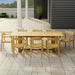 Westminster Teak Horizon 9pcs Teak Dining Set shown on a tiled patio near a house with columns, featuring a large teak table surrounded by eight matching wooden armchairs