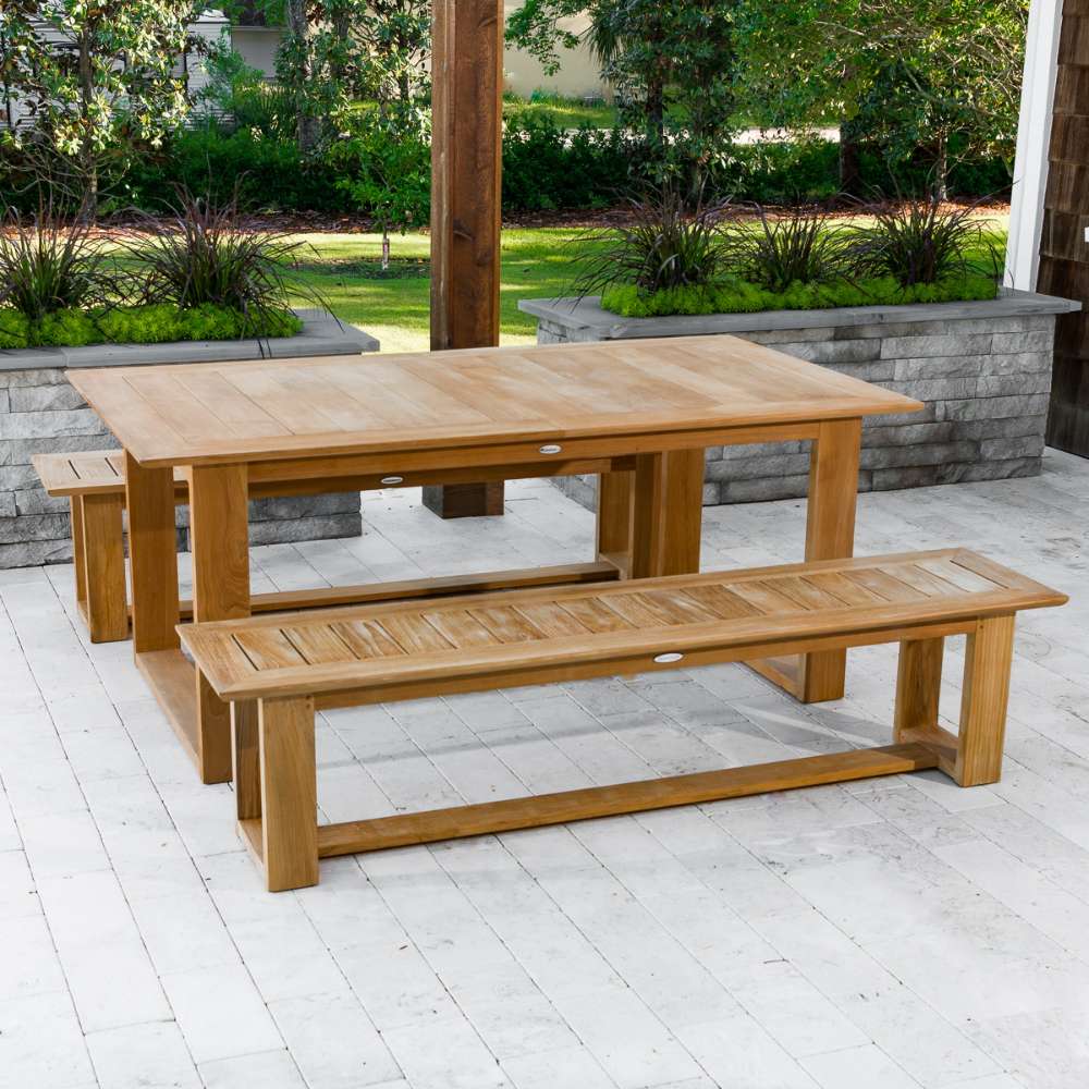 Westminster Teak Horizon Teak Dining Picnic Set on a deck with benches and table beside landscaped planters