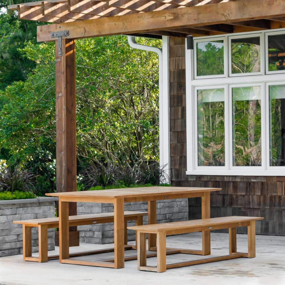 Westminster Teak Horizon Teak Dining Picnic Set under a pergola on a terrace surrounded by lush outdoor plants