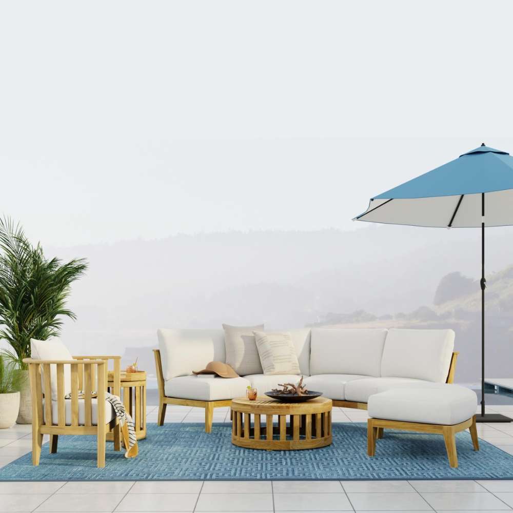 Westminster Teak Kafelonia 6pc Sofa Sectional Set on a terrace with white cushions, teak tables, plants, and an umbrella