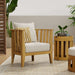 Westminster Teak Kafelonia Club Chair in a styled outdoor setting with white cushions, accent pillows, and a matching teak side table