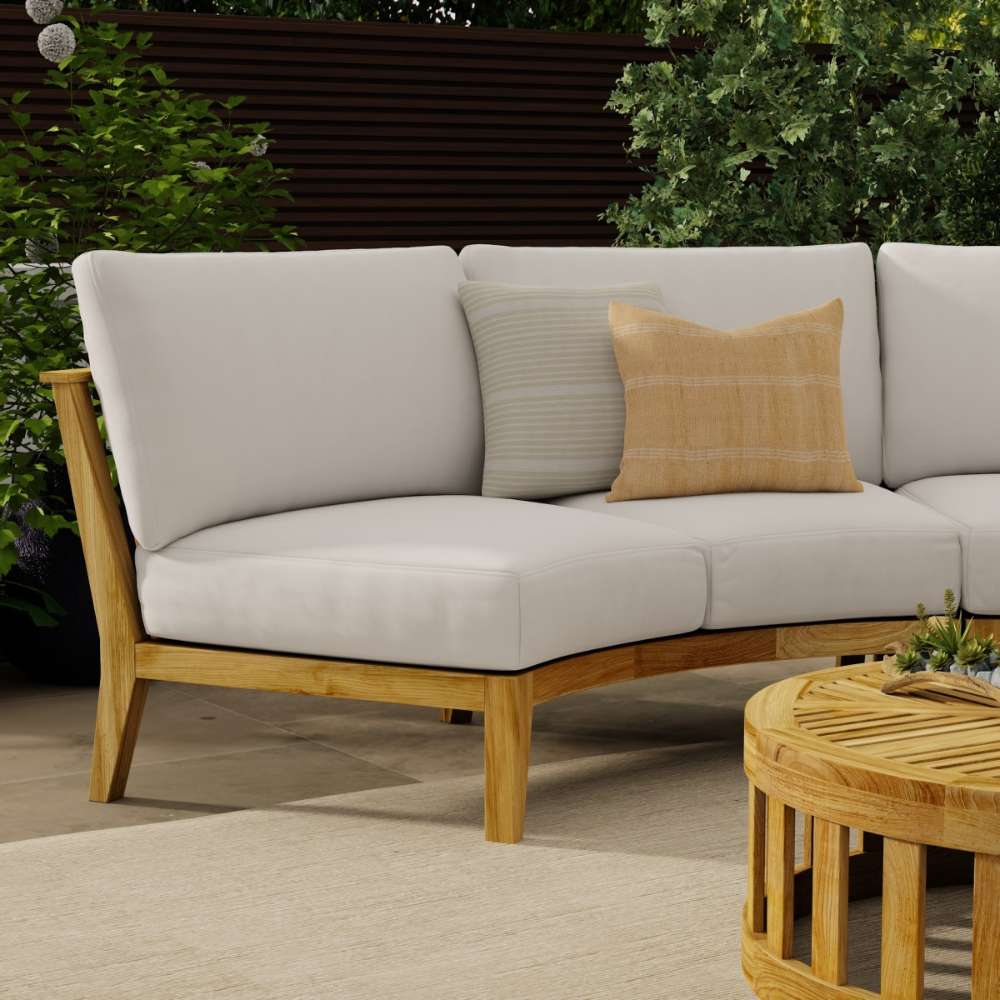 Westminster Teak Kafelonia Sofa Sectional is displayed on an outdoor patio with light-colored cushions and accent pillows