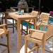 Westminster Teak Laguna 5pc Teak High Bar Set styled outdoors with a teak table and stools near a pool and patio seating