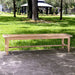 Westminster Teak Laguna Teak Backless Bench is a longer wooden bench sitting outdoors on a walkway