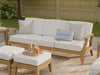 Westminster Teak Large Laguna Sofa on a patio with white cushions, accent pillows, and matching ottomans nearby