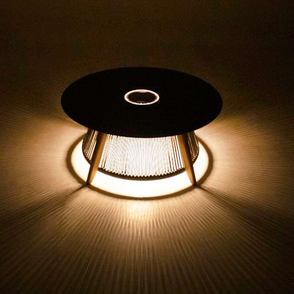 Westminster Teak Luna Coffee Table glowing at night with warm light shining through its rope base