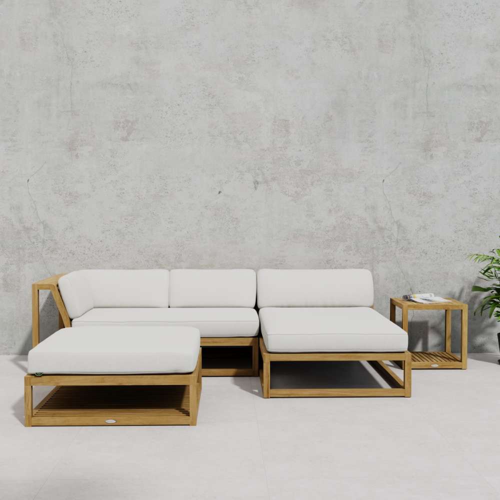 Westminster Teak Maya 4pc Lounge Set arranged on a patio with a sectional sofa, chaise, ottoman, and side table, with a magazine resting on the table next to a potted plant