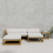 Westminster Teak Maya 4pc Lounge Set arranged on a patio with a sectional sofa, chaise, ottoman, and side table, with a magazine resting on the table next to a potted plant