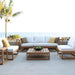 Westminster Teak Maya 6pc Lounge Sofa Set sits on a seaside patio with a palm tree and ocean view, including a coffee table with a bowl of green apples and neutral cushions