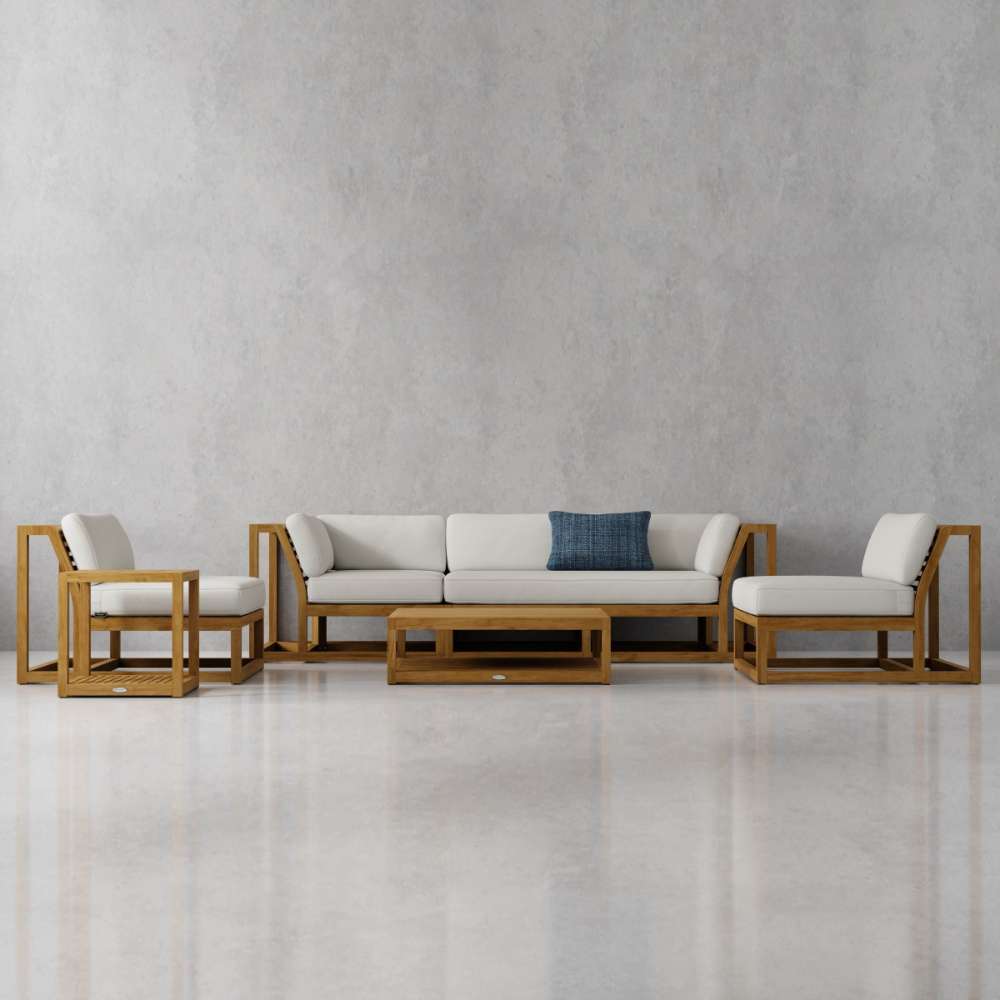 Westminster Teak Maya 6pc Lounge Sofa Set styled in a room setting with a grey wall, featuring light cushions and a single blue accent pillow on the sofa