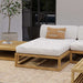 Westminster Teak Maya Chaise features a thick light cushion on a teak frame placed on a patio rug beside a table, potted plant, and glass door