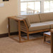 Westminster Teak Maya Corner Sectional appears indoors as a corner seat with a side table extension, showcasing its sturdy teak frame and neutral cushions in a cozy living space