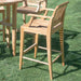 Westminster Teak Somerset Backless Bar Stool outdoors on grass beside a matching teak bar table