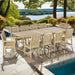 Westminster Teak Veranda 11pc Teak Dining Set placed outdoors near a pool with a large teak table and multiple chairs overlooking a scenic water view