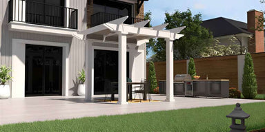White Structureworks Marquis Fiberglass Pergola covers a small patio seating area outside a two-story house with a balcony and landscaped yard