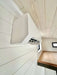White mini-split air conditioner is mounted high on the wall inside Sawmill Structures Wanderlove Tiny Home for efficient climate control