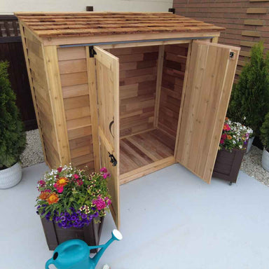 With both doors wide open, the Outdoor Living Today Grand Garden Chalet with cedar roof reveals a spacious and unfinished wooden interior perfect for storing outdoor essentials